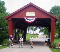 Riders pass under a covered bridge